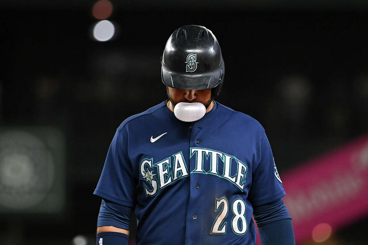 Seattle Mariners' Eugenio Suarez blows a bubble in the dugout