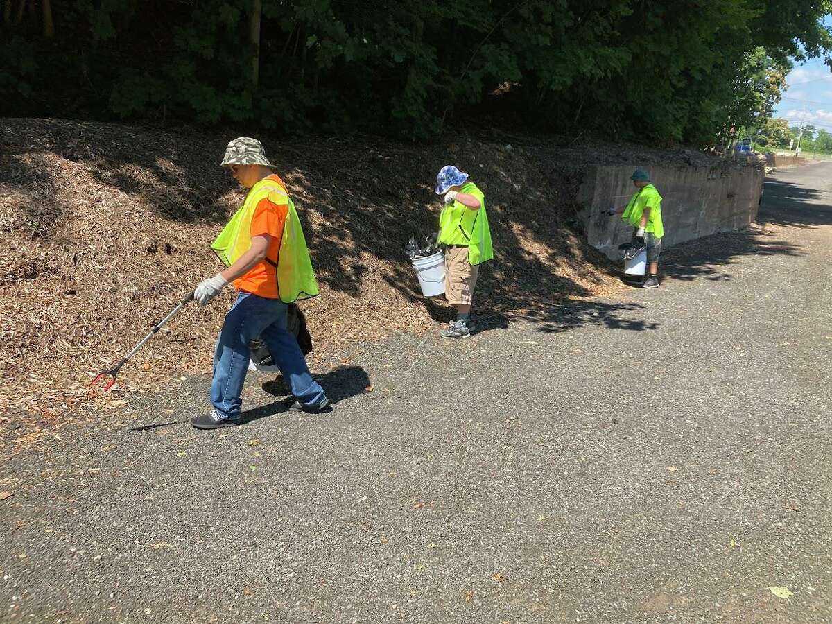 A crew from Opportunity Works Connecticut picks up nips bottles and other trash Wednesday in Vernon's Gene Pitney Memorial Park. The effort is being funded, in part, through the $44,235 the town received in the last year from the sale of nearly of 884,701 nips bottles. 