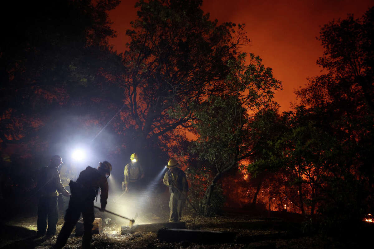   Firefighters mop up hot spot like oak fire moves through area on July 23, 2022 near Mariposa, California. 