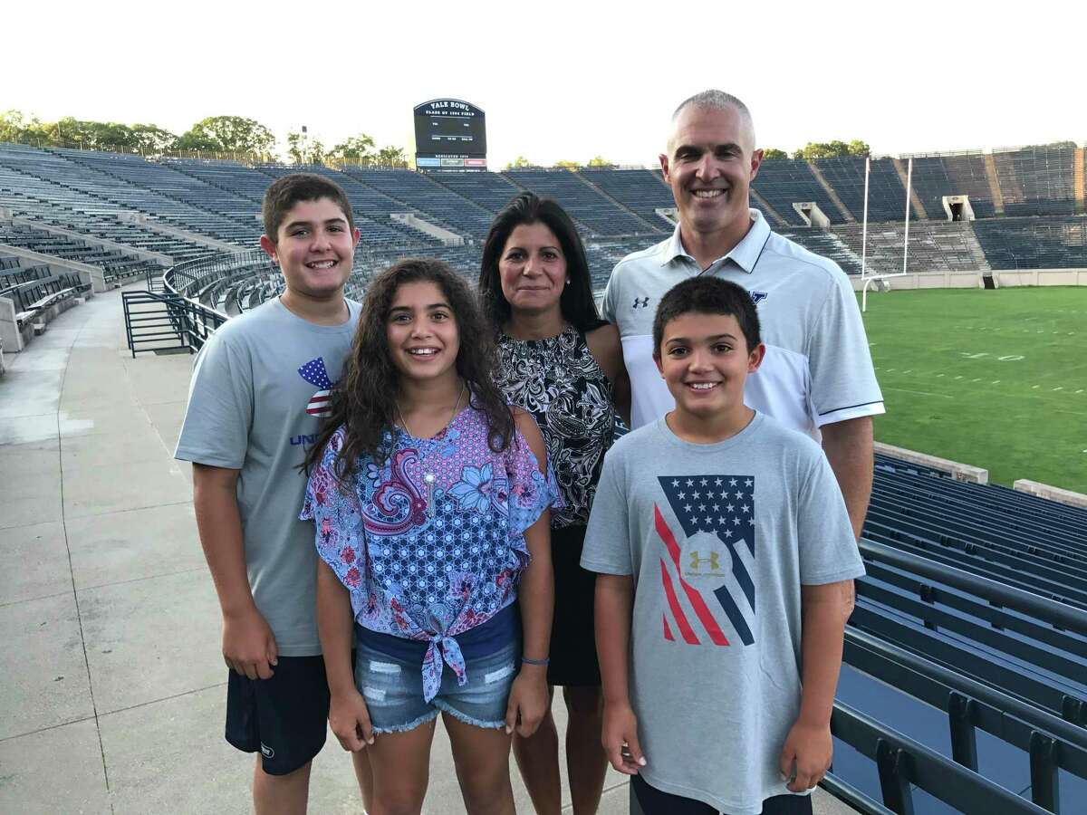 Yale football coach Tony Reno poses with his family, including his son Dante, who will play football at South Carolina.