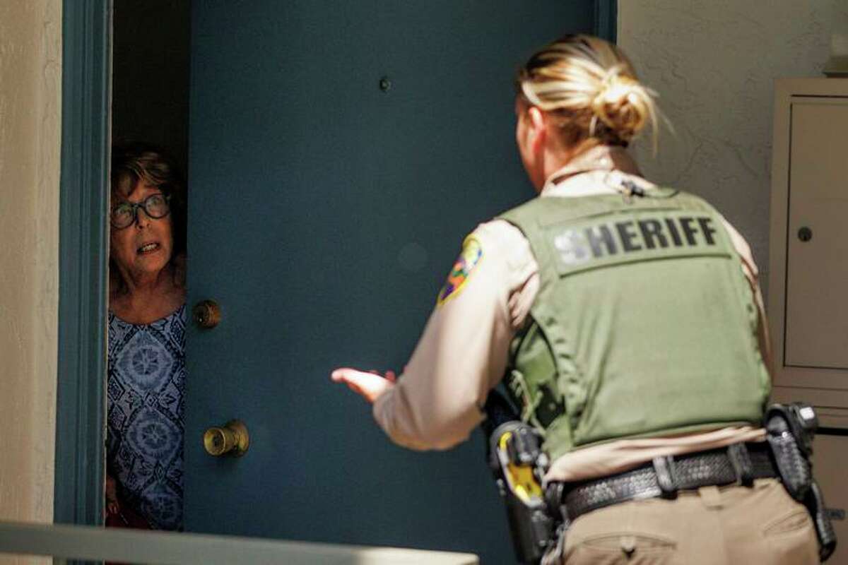 A Marin County sheriff’s deputy knocks on doors to evacuate residents from the fire near Marin City this month. The evacuation order was later lifted.