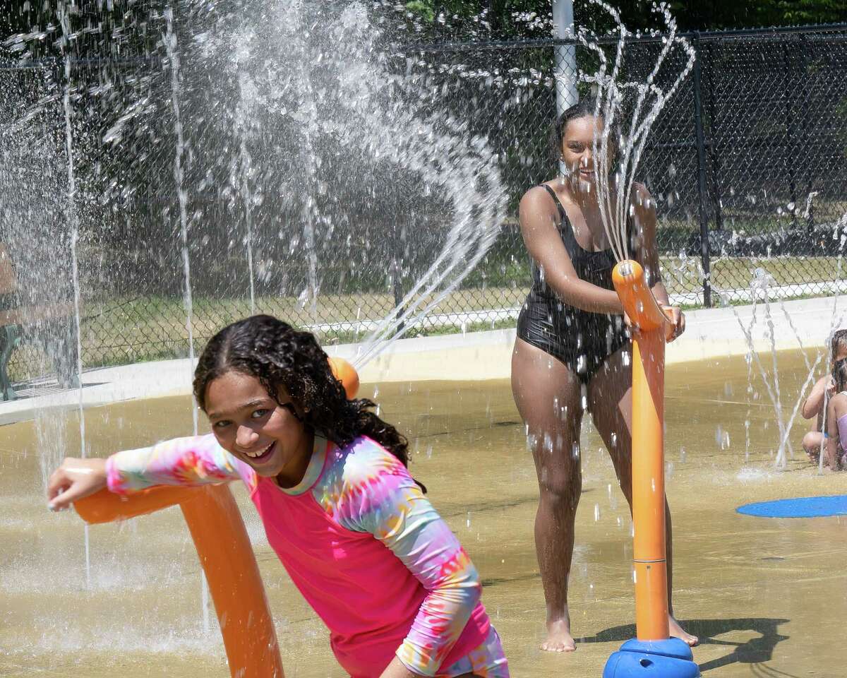 Aniya McKinnen (black suit) and Solangel Boivin cool off with a water gun fight at the Colonie splash pad at the Mohawk River Park on Sunday, July 24, 2022. (Jim Franco/Special to the Times Union)
