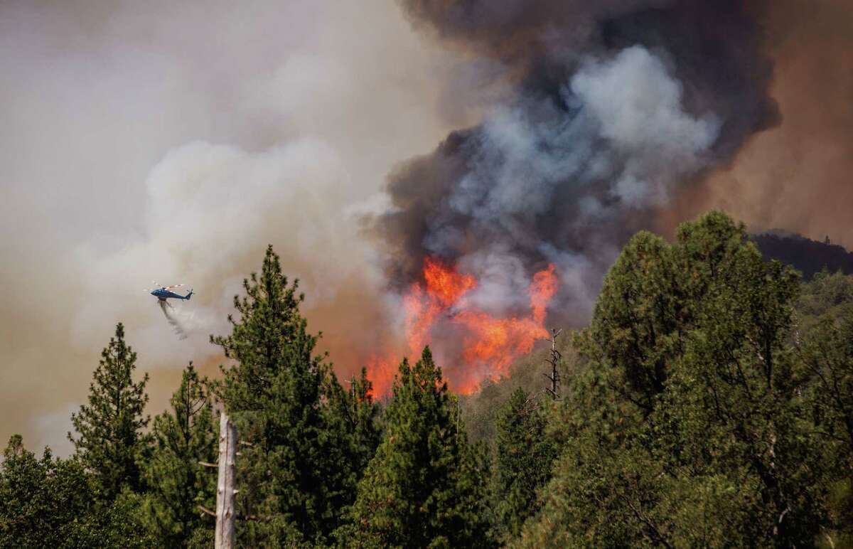 A helicopter drops water on the Oak Fire as it burns in unincorporated Mariposa County, Calif., on Sunday, July 24, 2022.