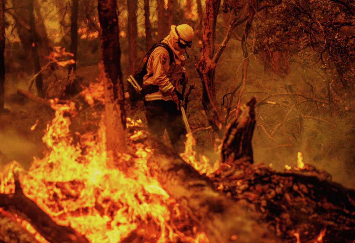 A firefighter battles flames from the Oak Fire in unincorporated Mariposa County, Calif., on Sunday, July 23, 2022.