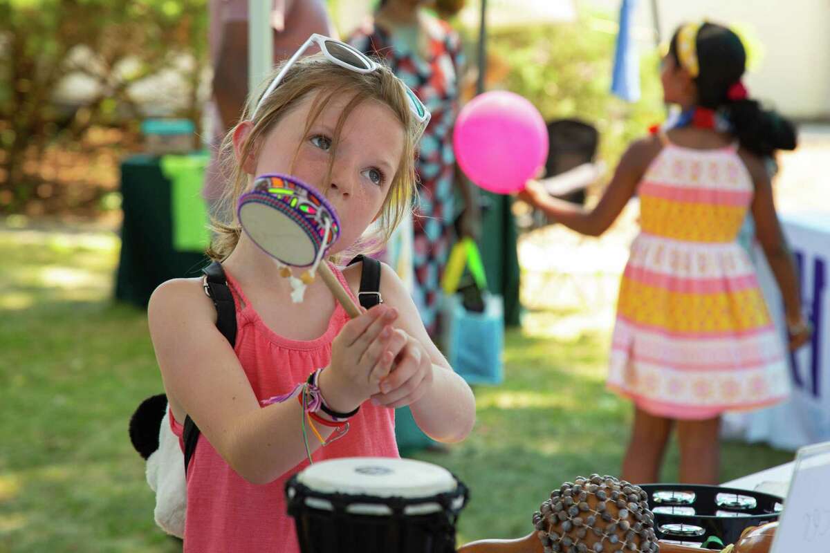 Teagan Reilly, 7 of Wilton tries out an African spin drum provided for play by Music on the Hill.