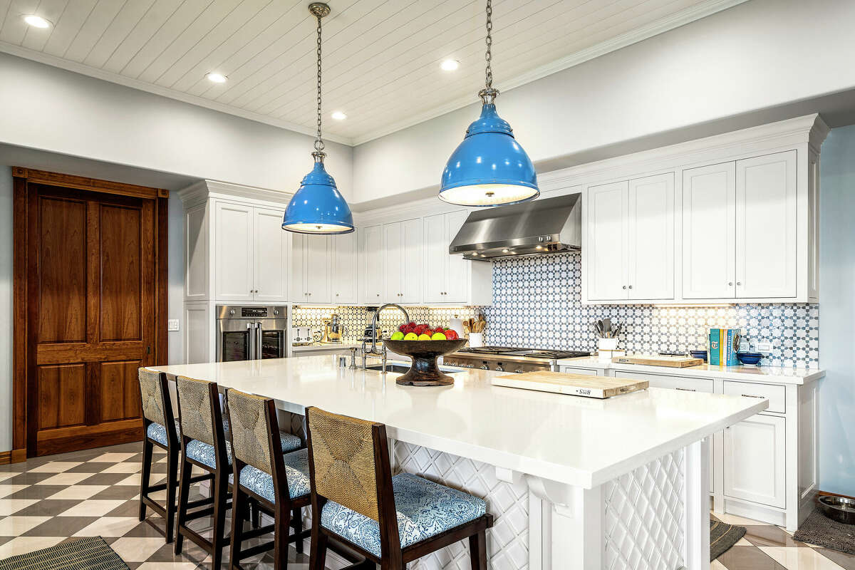 A chef's kitchen decorated with blue light fixtures.