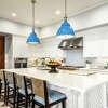 A chef's kitchen decorated with blue light fixtures.
