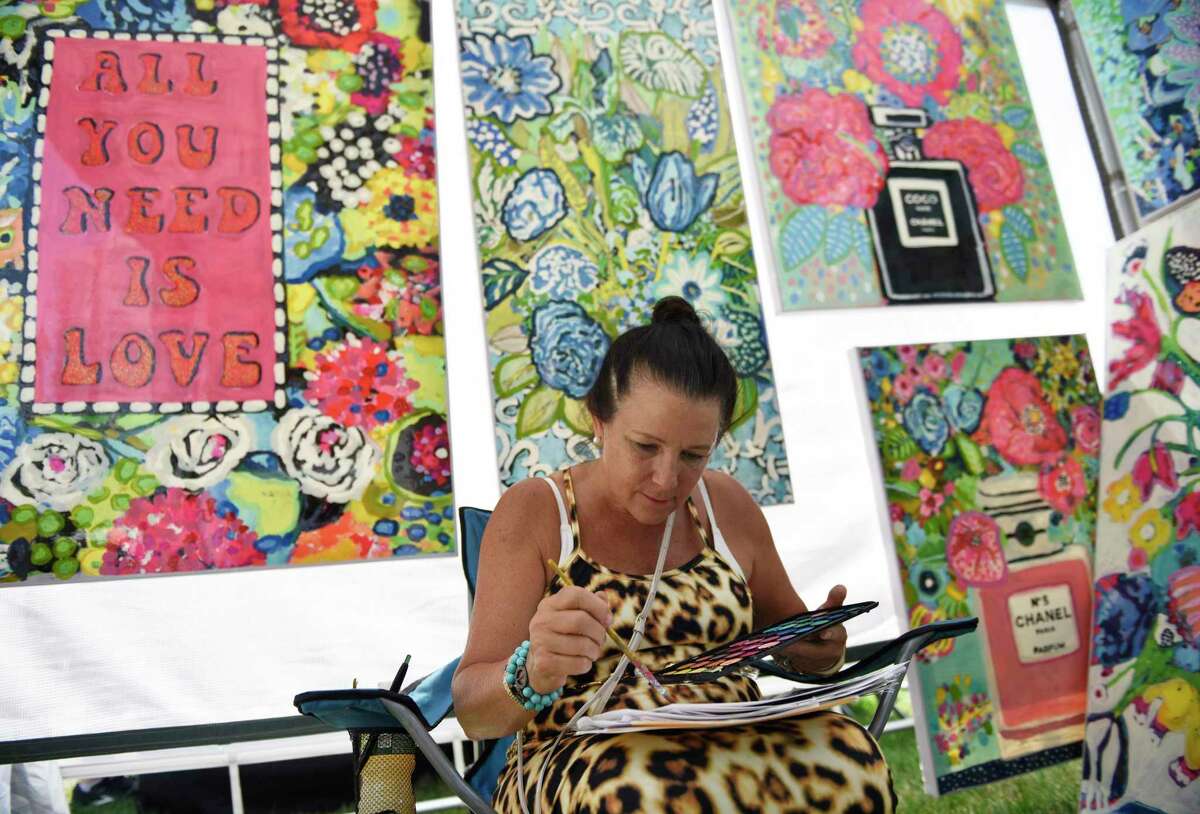 Philadelphia artist Andee Ax paints at her booth at the Stamford Art Festival at Harbor Point in Stamford, Connecticut, Sunday, July 24, 2022. The seventh annual juried exhibition showcased one-of-a-kind works in a variety of mediums, including painting, sculpture, metalwork, printmaking , jewelry, etc.  The event included demonstrations, hands-on art projects and children's activities.