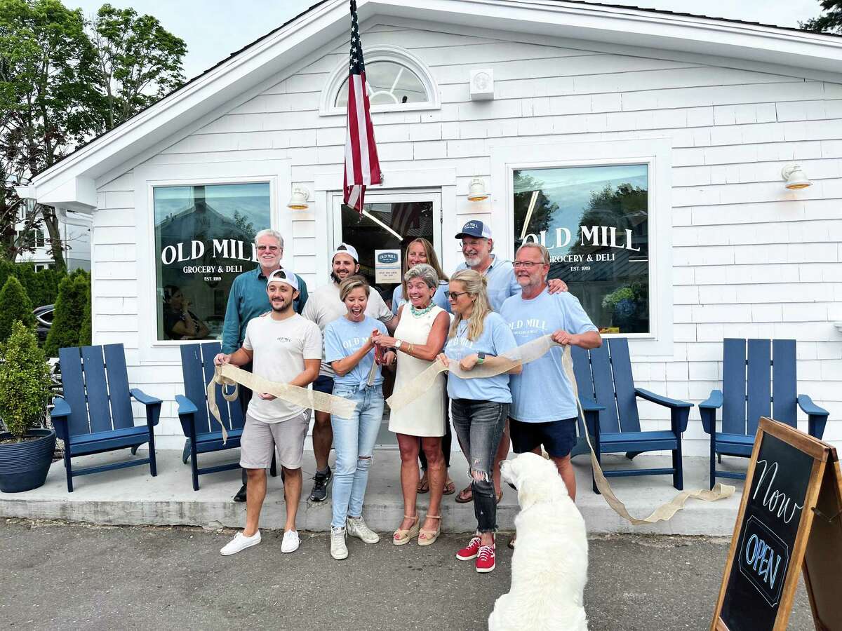 Members of Old Mill Grocery & Deli and the Westport community gather to cut the ribbon on the store’s opening day in Westport, Conn. July 25, 2022.