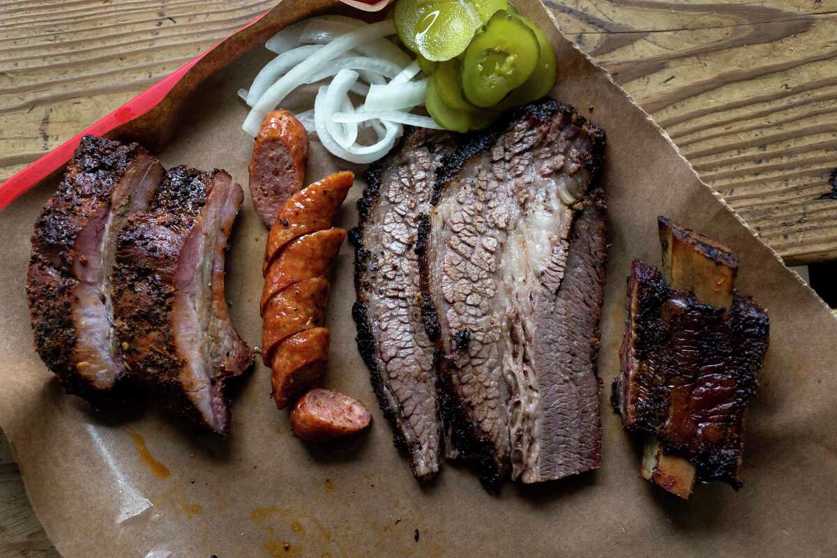 A tray of pork ribs, sausage link, brisket and beef ribs are shown at The Barbecue Station in San Antonio.