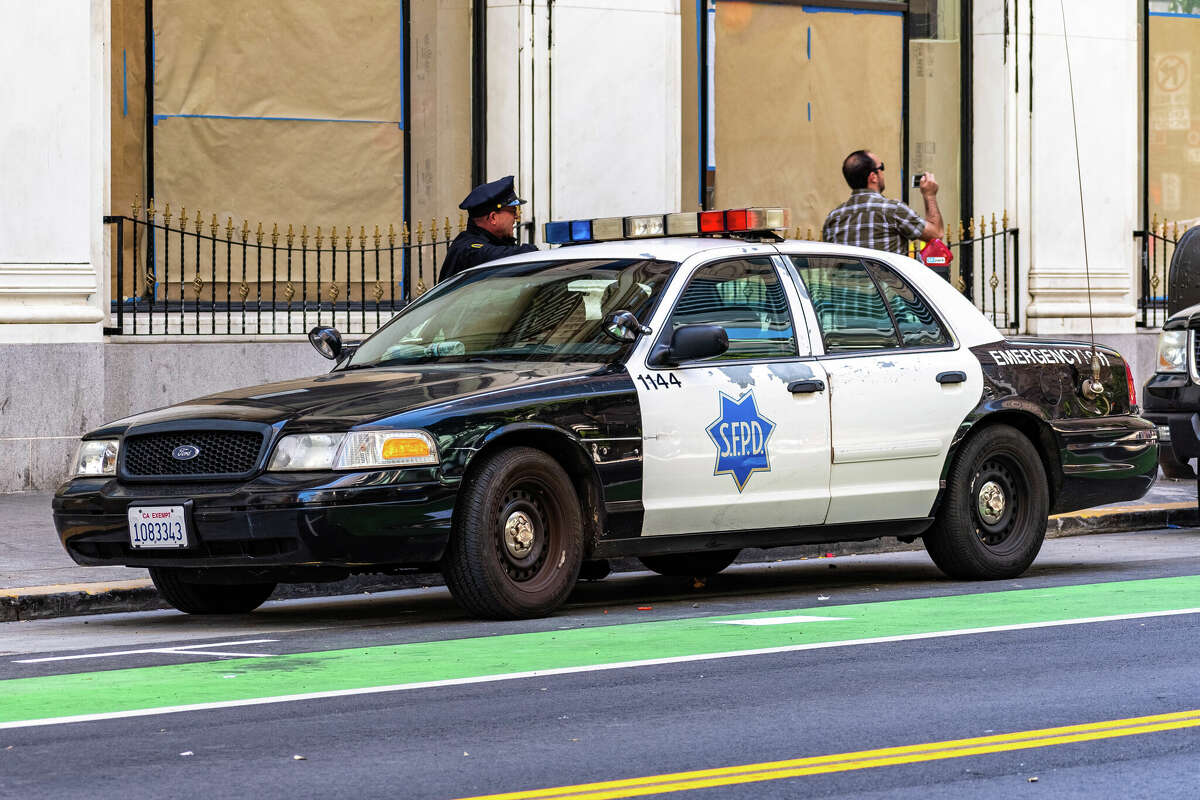 A stock photo shows a San Francisco Police Department police car parked close to Market Street.