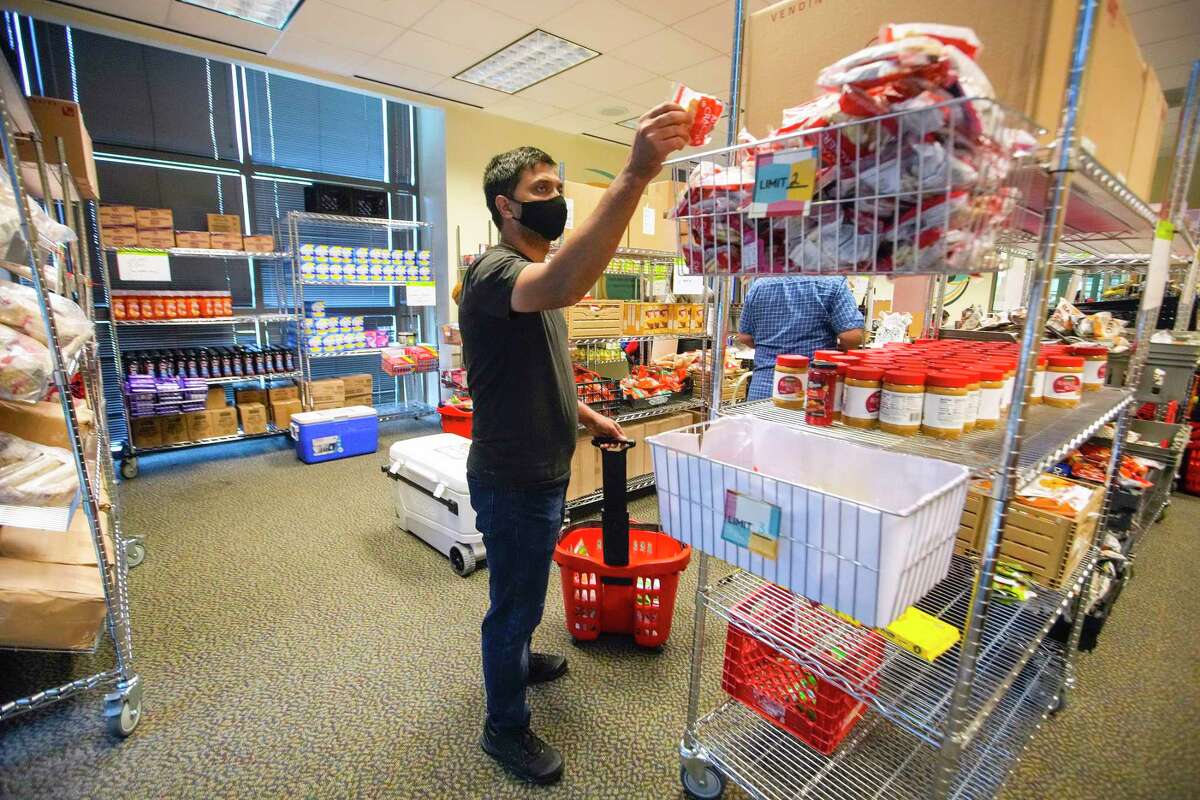 Komal Kukkar, a UH doctoral student in neuroscience, picks out groceries from the Cougar Cupboard.
