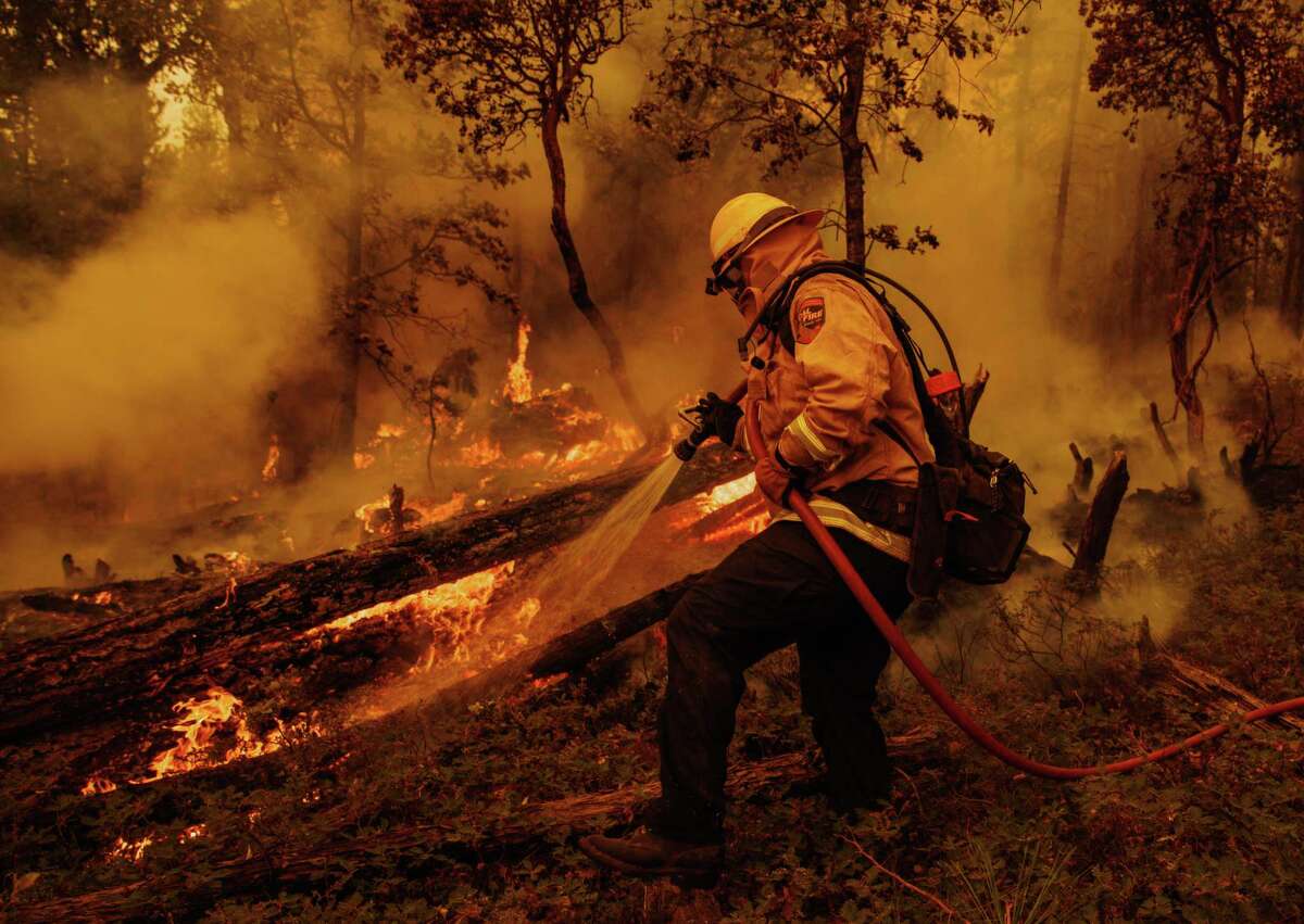 A firefighter battles flames from the Oak Fire in unincorporated Mariposa County, Calif., on Sunday, July 24, 2022. (Ethan Swope/San Francisco Chronicle via AP)