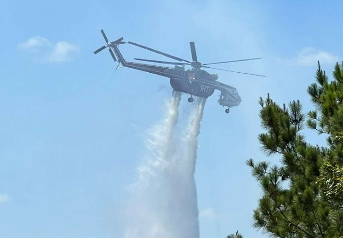 A helicopter drops water on the Nelson Creek Fire in Walker County. The fire burned more than 1,800 acres between July 18 and July 25, according to the Texas A&M Forest Service.