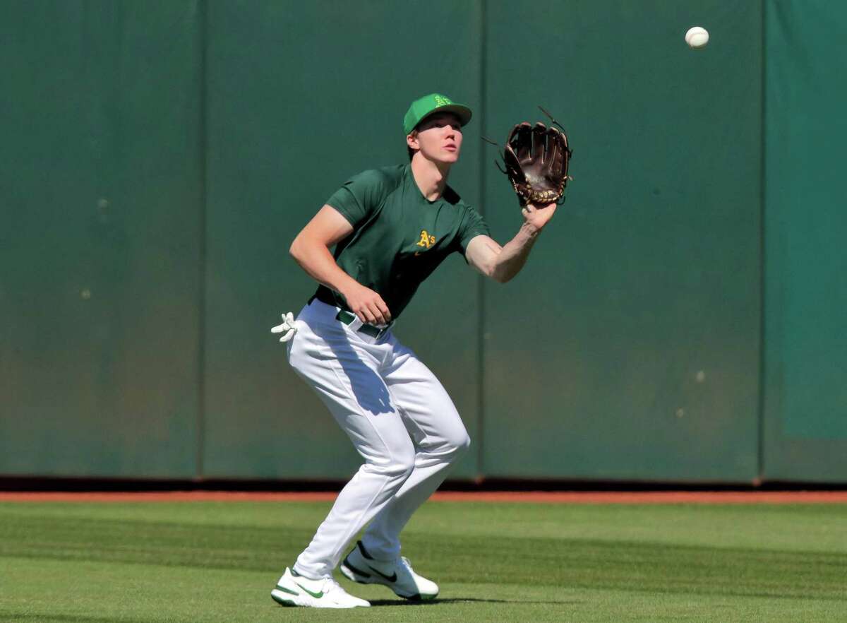 Henry Bolte catches a ball in the outfield during batting practice at the Coliseum in Oakland, Calif., on Monday, July 25, 2022. Bolte is the A’s second round draft pick, outfielder from Palo Alto High School, and the team brought him in today to sign his contract and work out/take batting practice