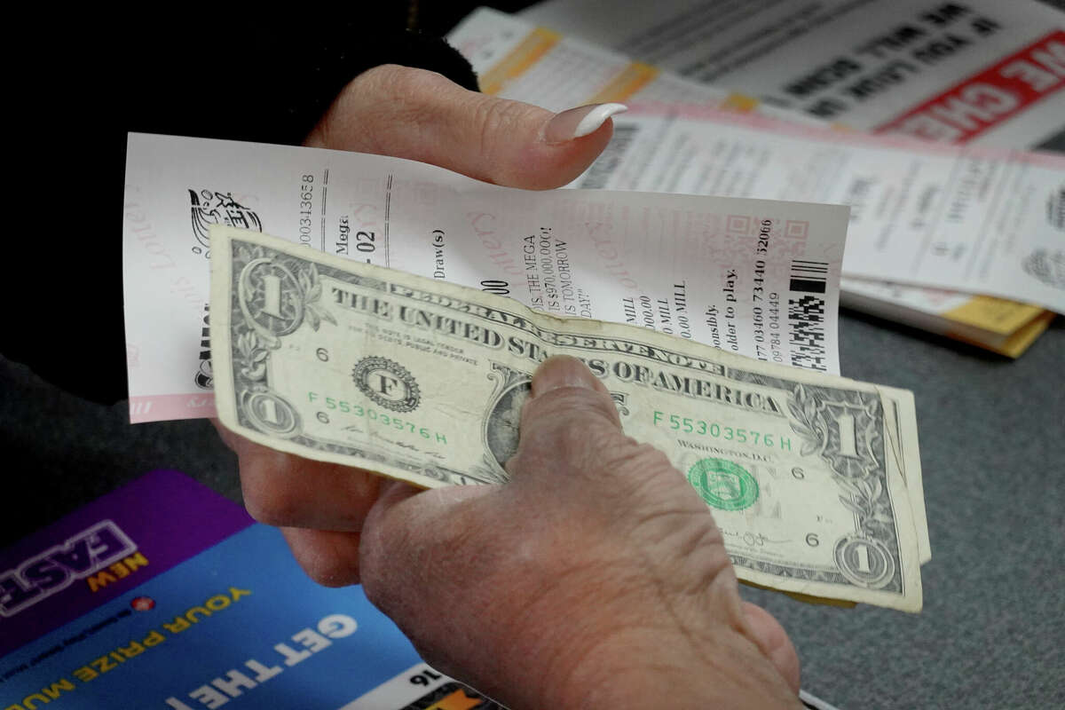 A customer purchases a Mega Millions lottery ticket at a 7-Eleven store in the Loop on January 22, 2021 in Chicago, Illinois. The jackpot in the drawing has climbed to $810 million, the third highest in the game's history.