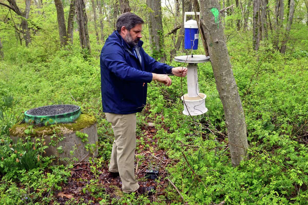 John Shepard from the Connecticut Agricultural Experiment Station places a mosquito trap in a wildlife preserve in Milford.