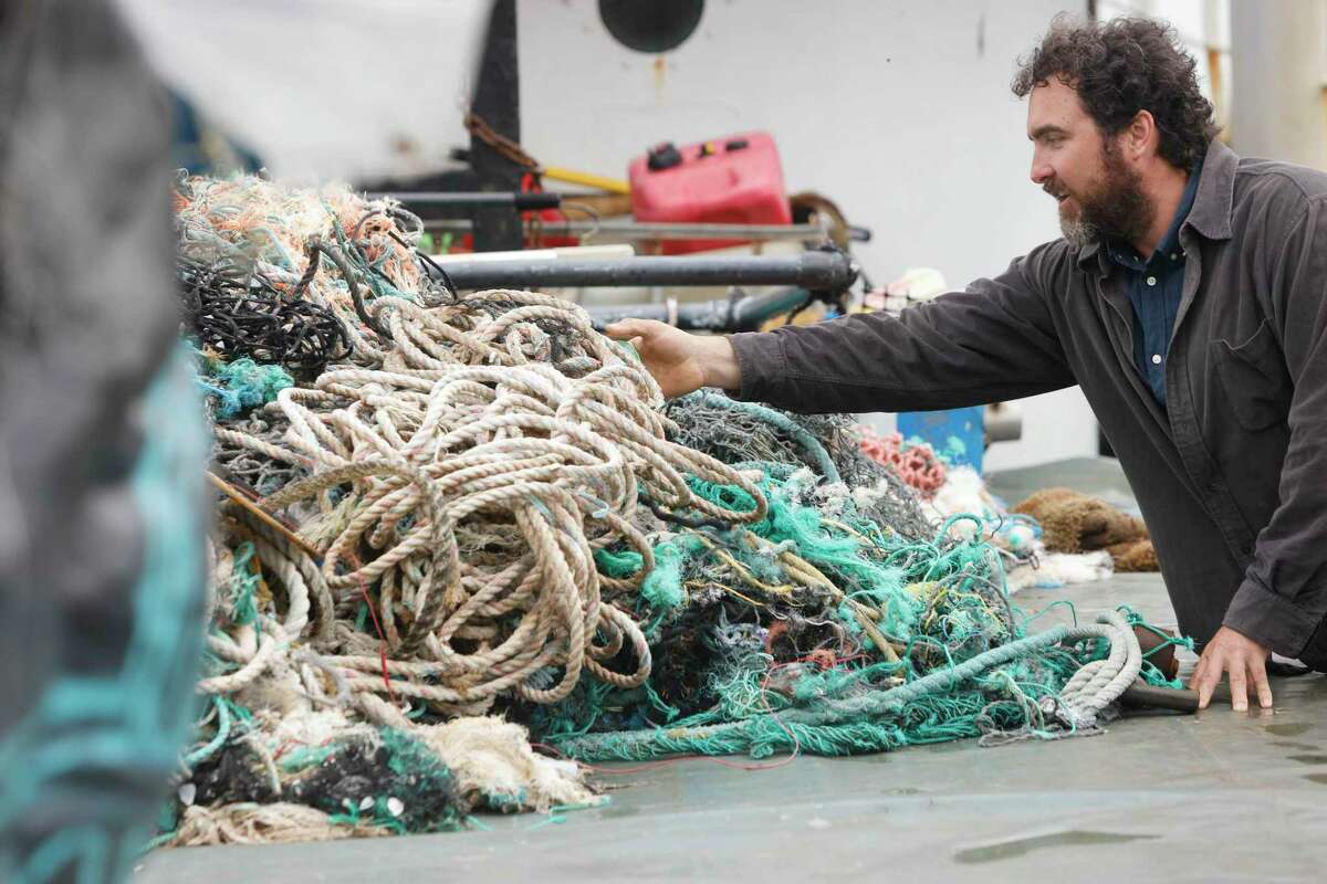 Capt. Locky MacLean looks over plastic debris collected from the North Pacific Gyre by Ocean Voyages Institute ship during a 45-day cleanup.