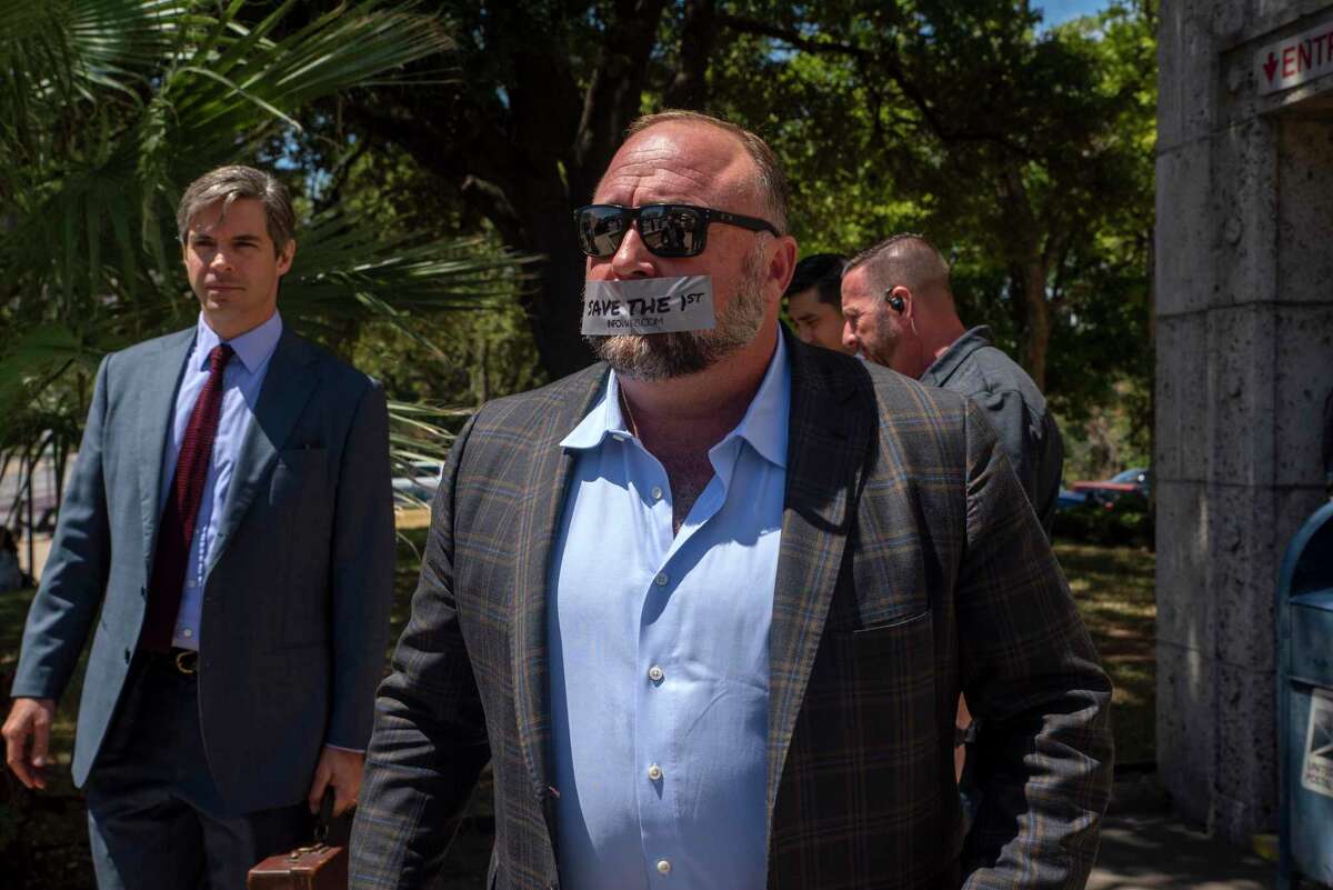 Alex Jones speaks to reporters outside the 459th Civil District Court on Tuesday, July 26, in Austin, TX. Reynal is the attorney for Alex Jones. Jones, is being sued by Neil Heslin and Scarlett Lewis over his repeated claims that the 2012 shooting at Sandy Hook Elementary was a "false flag operation" conducted by the government.