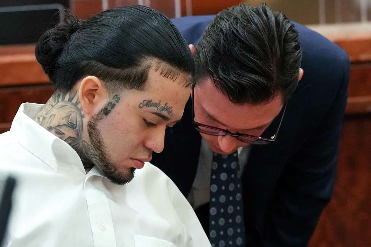 Robert Soliz, left, talks to his attorney Wade Smith during opening arguments in his trial Tuesday, July 26, 2022 in Houston. Soliz is accused of killing HPD Sgt. Sean Rios in November 2020.
