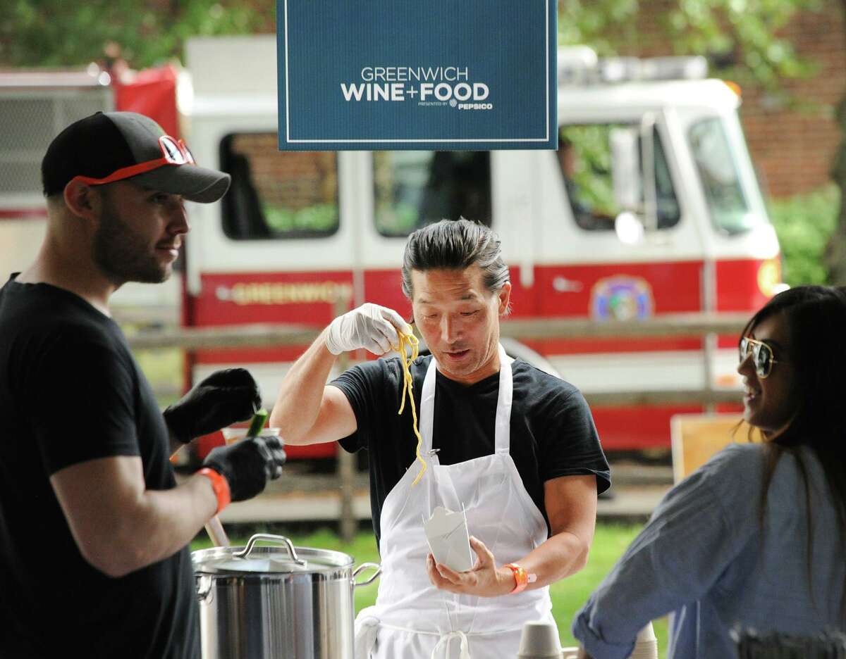 At center, Chnoo Berlind of Lulu Chinese Restaurant on Lewis Street in Greenwich, prepares a noddle dish during the annual Greenwich Wine + Food Festival at Roger Sherman Baldwin Park in Greenwich, Conn., Saturday, Sept. 22, 2018. Greenwich Wine + Food is returning in 2022 to celebrate its 10-year anniversary, after the pandemic canceled the popular, celebrity-attended food and wine event for two years in a row.