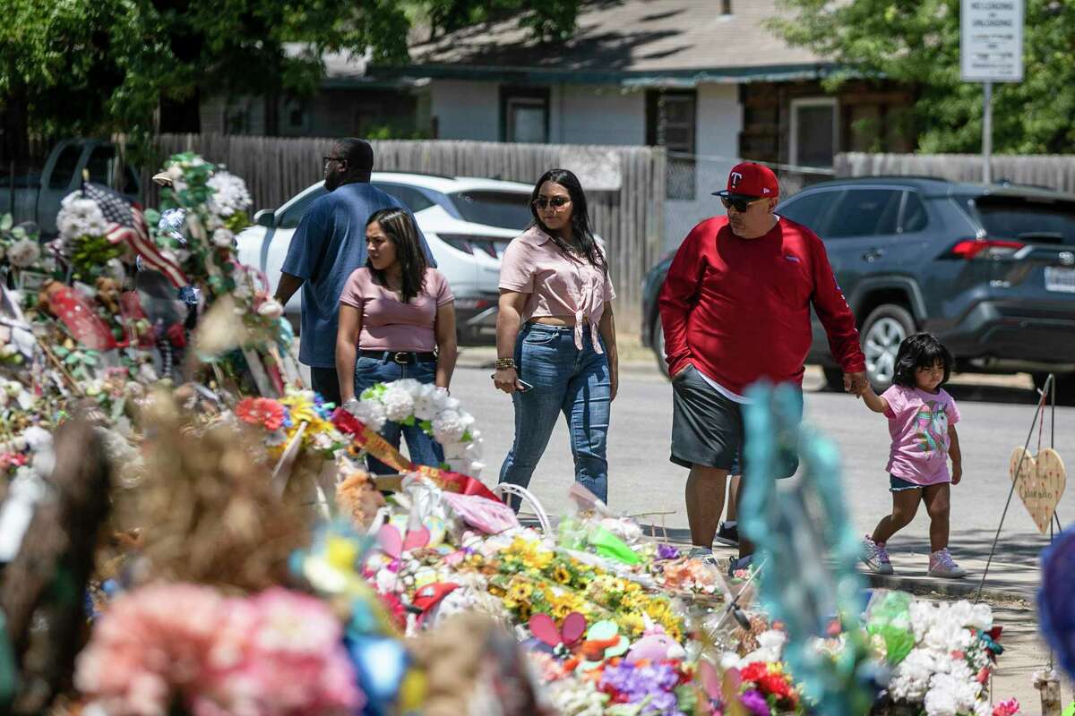 People visit the memorial for victms of the Robb Elementary School massacre outside the campus in Uvalde on Saturday.