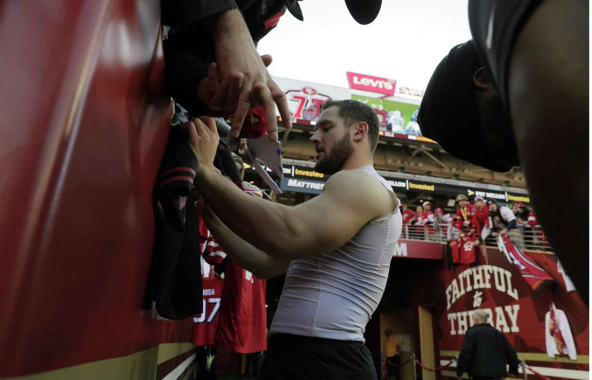 Nick Bosa (97) signs autographs during warmups before the San Francisco 49ers played the Houston Texans at Levi’s Stadium in Santa Clara, Calif., on Sunday, January 2, 2022.