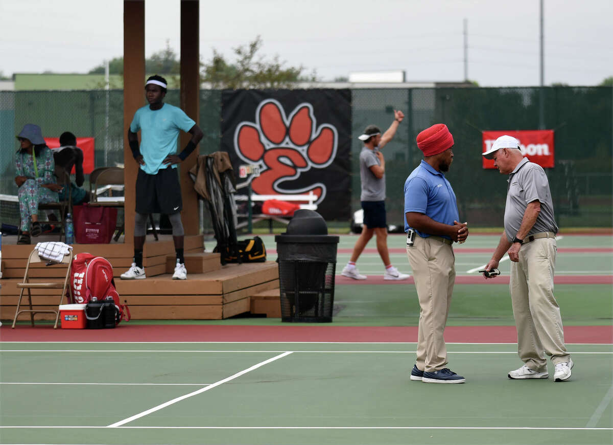 Officials check Court No. 4 before the start of play Tuesday after rain played havoc on the schedule.