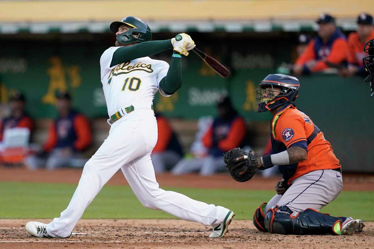 Oakland Athletics' Chad Pinder (10) watches his grand slam in front of Houston Astros catcher Martin Maldonado during the third inning of a baseball game in Oakland, Calif., Tuesday, July 26, 2022. (AP Photo/Jeff Chiu)