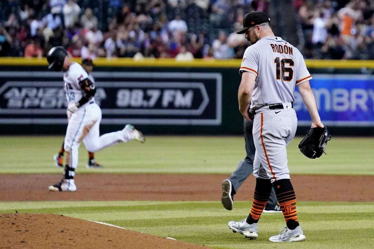 San Francisco Giants starting pitcher Carlos Rodon (16) walks around the mound after giving up a three-run home run to Arizona Diamondbacks' Christian Walker, left, during the third inning of a baseball game Tuesday, July 26, 2022, in Phoenix. (AP Photo/Ross D. Franklin)