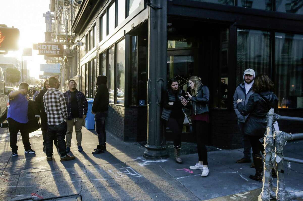 People chat outside Black Cat bar as they wait for it to open on Eddy Street in San Francisco, California, on Sunday, March 5, 2017.