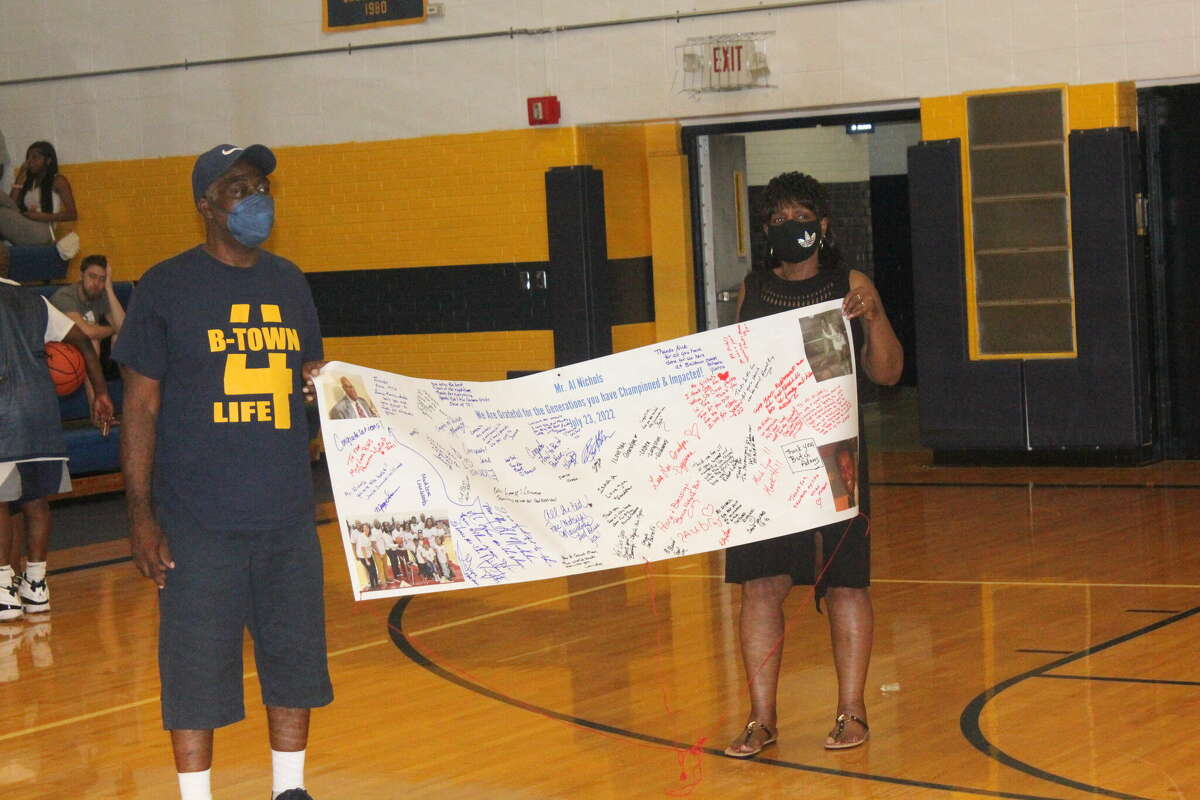 Abe and Yvonne Williams hold the banner honoring former Baldwin administrator Al Nichols during Saturday's alumni basketball game.