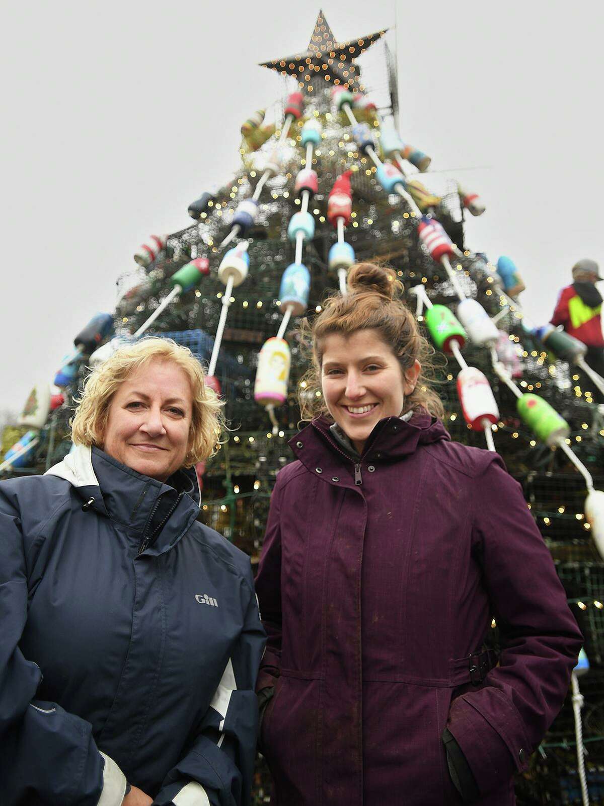Milford Arts Council Executive Director Paige Miglio, left, and Downtown Milford Executive Director Makayla Silva at the groups' first ever lobster trap tree at Lisman Landing in Milford, Conn. on Saturday, December 11, 2021.