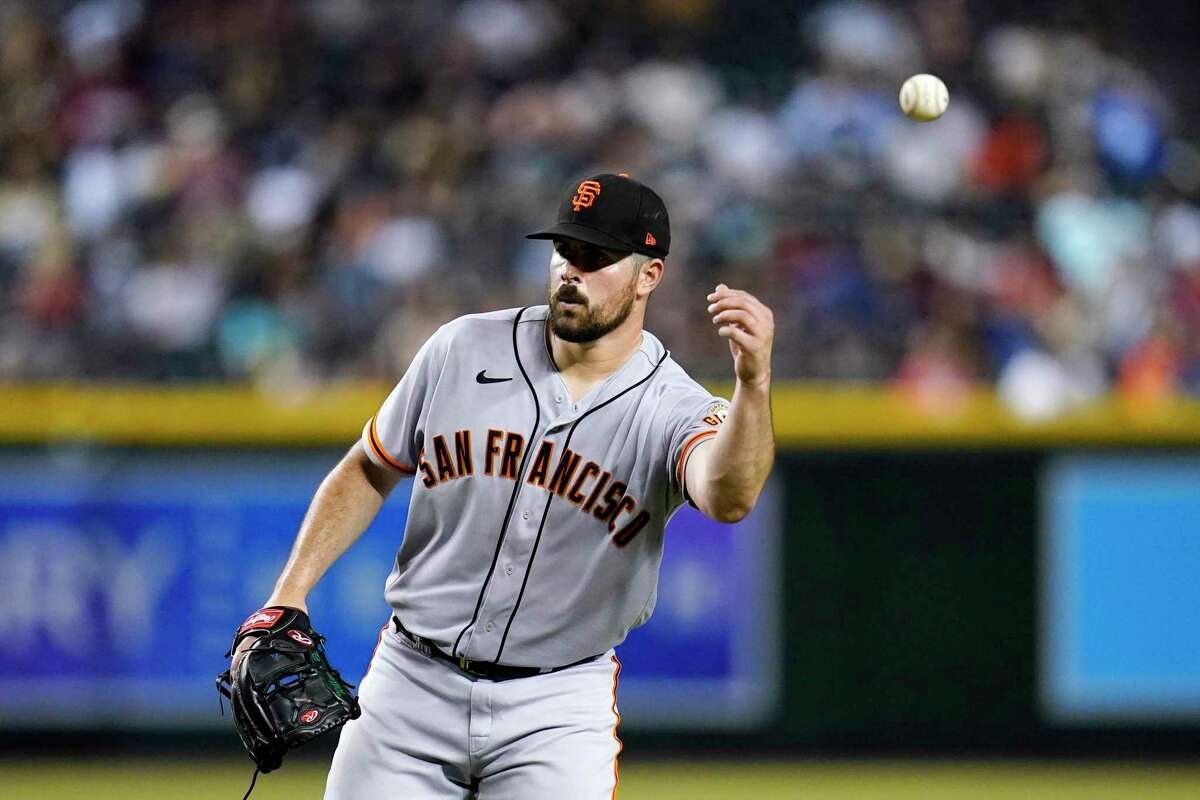 San Francisco Giants starting pitcher Carlos Rodon tosses a baseball out of play during the fourth inning of a baseball game against the Arizona Diamondbacks Tuesday, July 26, 2022, in Phoenix. (AP Photo/Ross D. Franklin)
