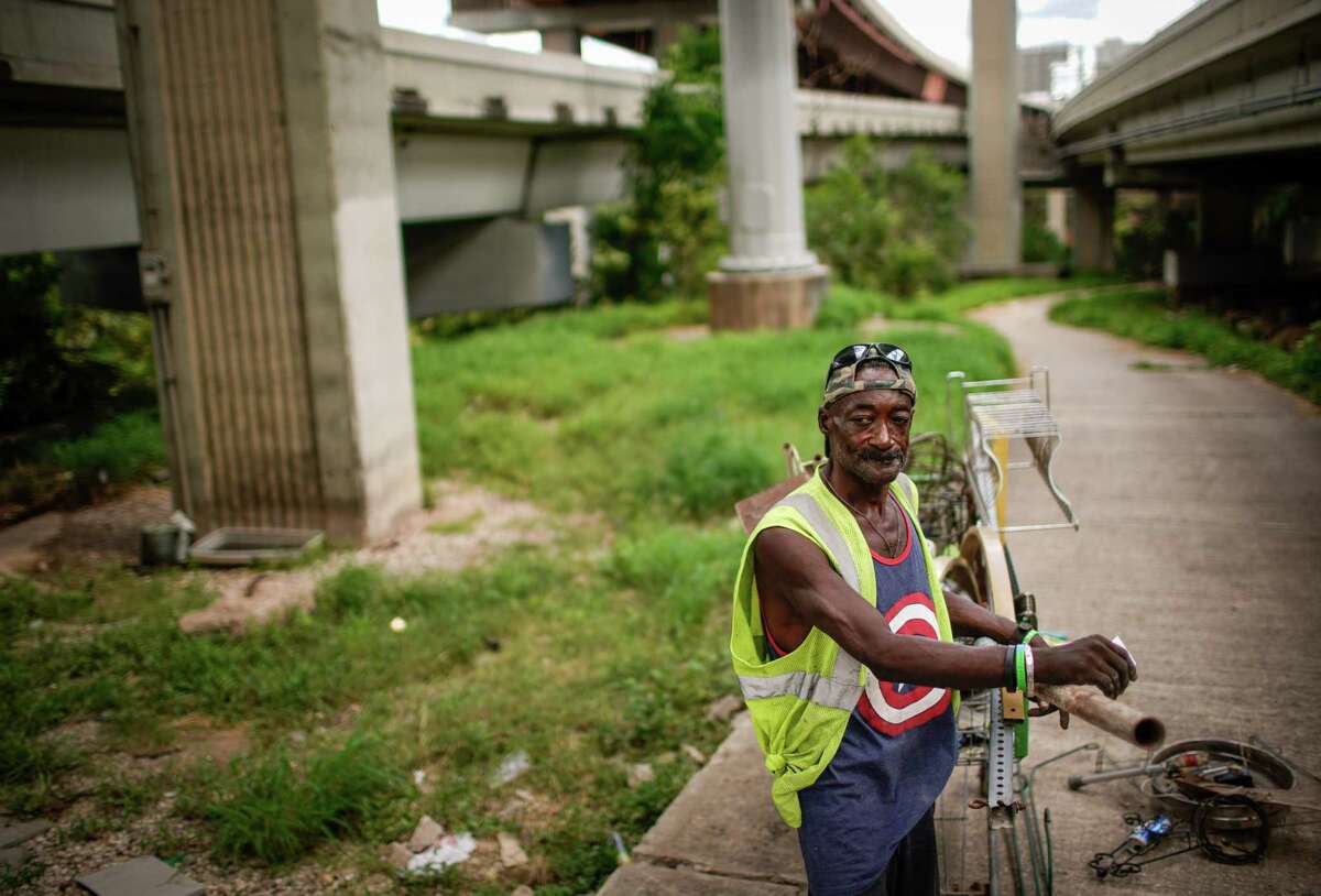 Leon Brown gathers metal under Highway 59 to sell to a scrapyard on July 15, 2022, near Minute Maid Park in Houston. Brown said that he had been told he would need to relocate within a month as work progresses on an expansion of I-45 near downtown.