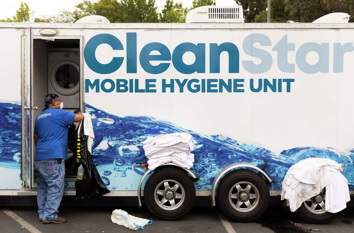 City of Fremont employee Timothy Daquioag works in the Clean Start laundry unit parked outside of Irvington Presbyterian Church.