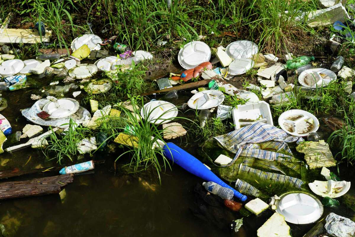 Garbage fills a ditch at an illegal dumping site in Fifth Ward, Tuesday, May 25, 2021, in Houston.