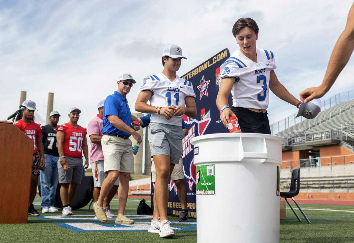 Alamo Height’s Rett Andersen drops peanut butter in a donation bucket during an event announcing this year’s Peanut Butter Bowl at Heroes Stadium in San Antonio, TX, on July 27, 2022. The Peanut Butter Bowl, started in 2016, is a series of local high school football games with23 local teams will donating their proceeds and jars of peanut butter to local food banks.
