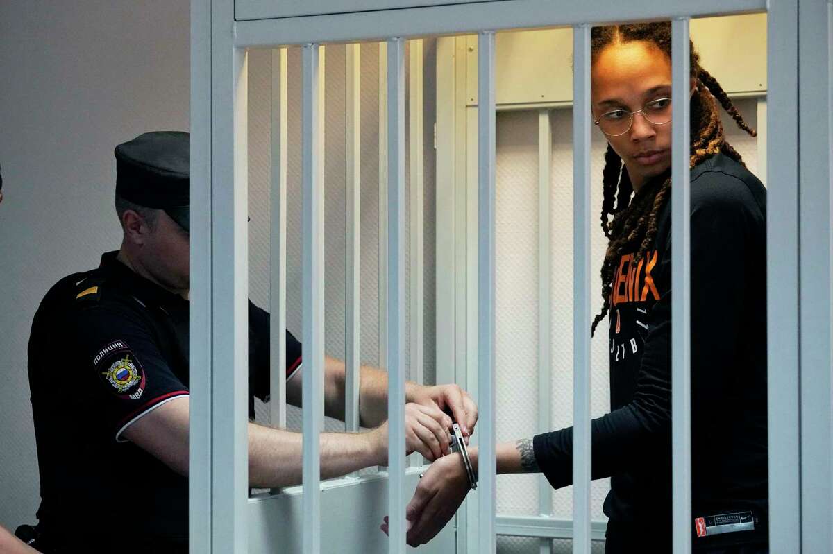 A policeman removes the handcuffs from WNBA star and two-time Olympic gold medalist Brittney Griner in a courtroom prior to a hearing, in Khimki just outside Moscow, Russia, Wednesday, July 27, 2022. American basketball star Brittney Griner returned Wednesday to a Russian courtroom for her drawn-out trial on drug charges that could bring her 10 years in prison of convicted. (AP Photo/Alexander Zemlianichenko, Pool)