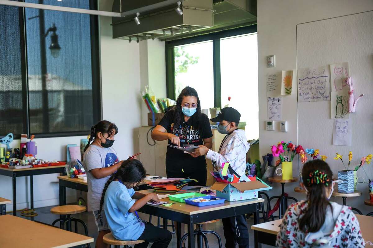 L'enseignante Cristina Velazquez (au centre) aide les élèves lors d'un cours d'art et d'artisanat à EPACENTER à East Palo Alto, en Californie, le mardi 26 juillet 2022. EPACENTER est un nouveau centre de jeunesse communautaire de deux étages dans la communauté mal desservie d'East Palo Alto .