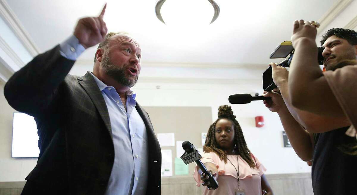 Alex Jones talks to media during a midday break during the trial at the Travis County Courthouse in Austin, Texas on Tuesday.