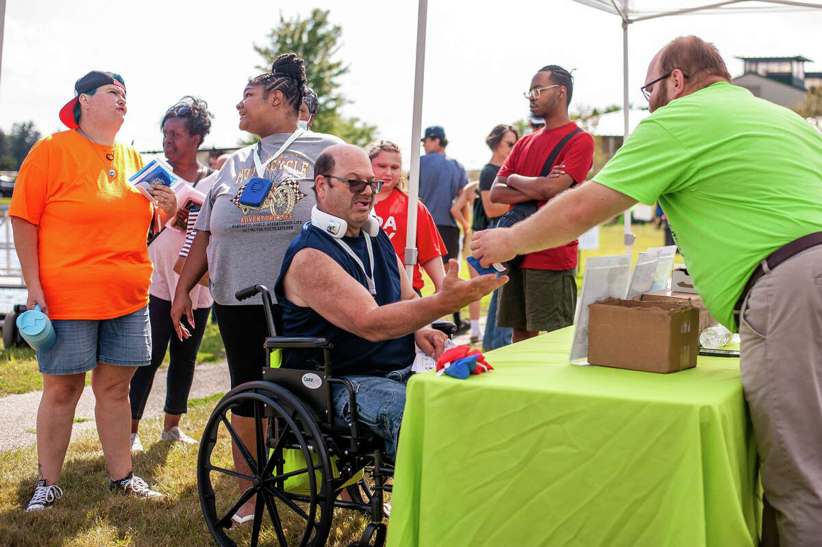 Midland resident Joseph Dopp (center) and his caregiver Armani Lowe (grey shirt), participates in an event celebrating the anniversary of the Americans with Disabilities Act on July 27, 2022 at Auburn City Park.