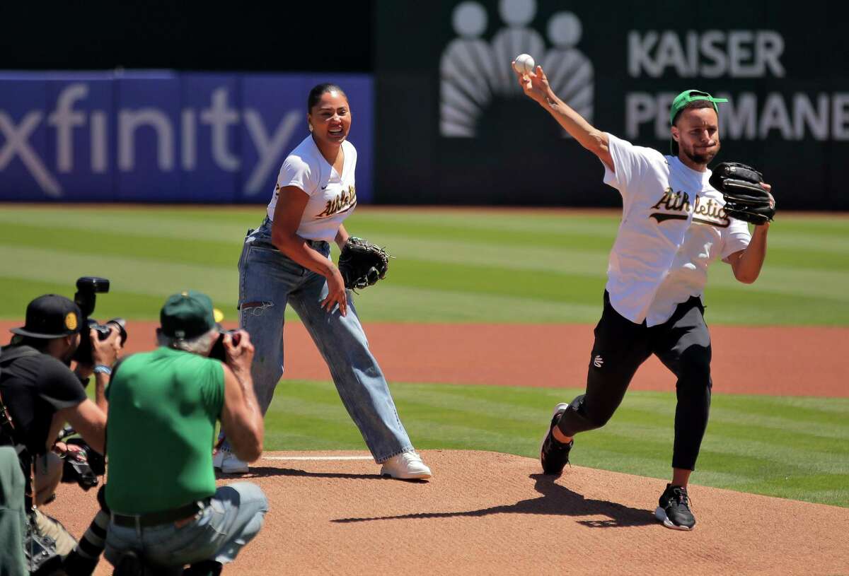 Stephen Curry, right, and Ayesha Curry threw out the first pitches before Wednesday’s Astros-A’s game at the Coliseum.