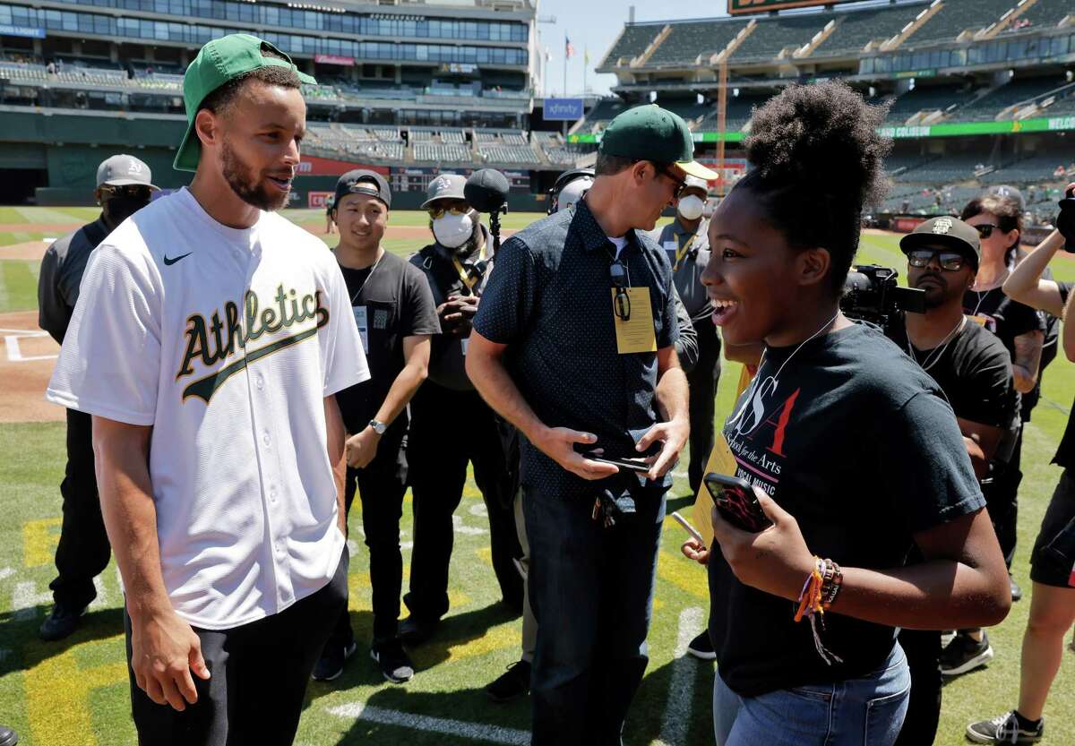 Stephen Curry chats with Nai Trawick of the Oakland School of the Arts who was preparing to sing the national anthem as he and Ayesha Curry gathered with fans at the first-ever Eat.Learn.Play. event at the Coliseum in Oakland, Calif., on Wednesday, July 27, 2022. E.L.P. benefits East Bay children in need, and about 1000 of the kids were in attendance at the game in the Stomper Zone.