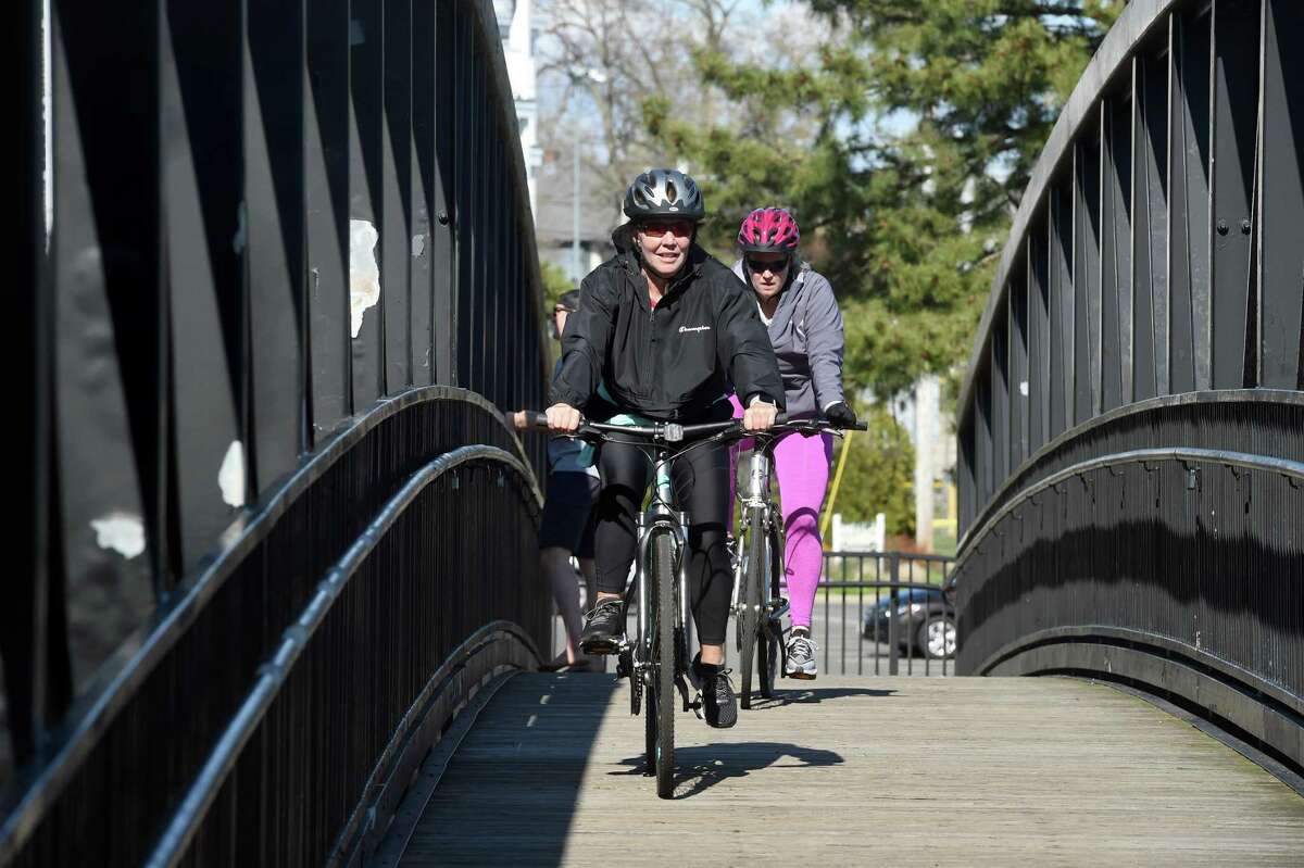 According to Steven Johnson, assistant public works director, Milford’s goal is to have a connected bike path throughout the city. Pictured is Paige Trevathan (left) and Melissa Sanford of Milford bike over the Hotchkiss Bridge in Milford on April 28, 2020.