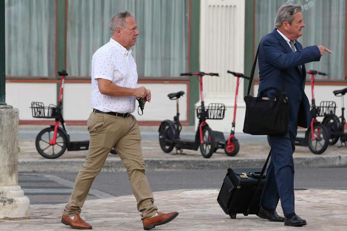Former San Antonio attorney Christopher Pettit, left, walks with his bankruptcy lawyer, Michael G. Colvard, in July. Colvard’s firm has sought to withdraw from representing Pettit and his now-defunct law firm in their bankruptcy case.