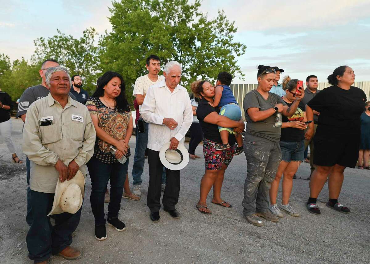 People gather on Wednesday, July 27, 2022, on Quintana Road in San Antonio on the spot where 53 migrants died in the summer heat on June 27. The migrants were from Honduras, Mexico and Guatemala.