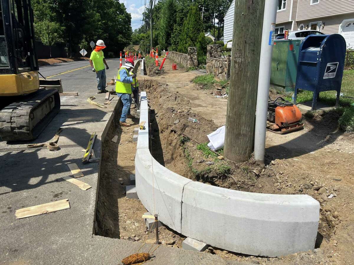 Construction crews with A Vitti Construction replace sidewalks along Highland Avenue on Wednesday, July 27, 2022. The new sidewalk will extend from Flax Hill Road to Charcoal Road to provide a safer route to three neighborhood schools.