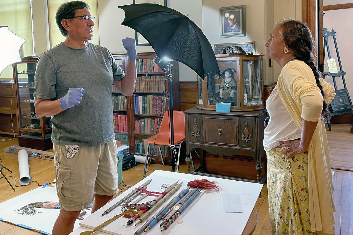 Leola One Feather (right) of the Oglala Sioux Tribe in South Dakota, talks with Jeffrey Not Help Him, also an Oglala Sioux tribe member, while Native American artifacts are photographed at the Founders Museum in Barre, Massachusetts