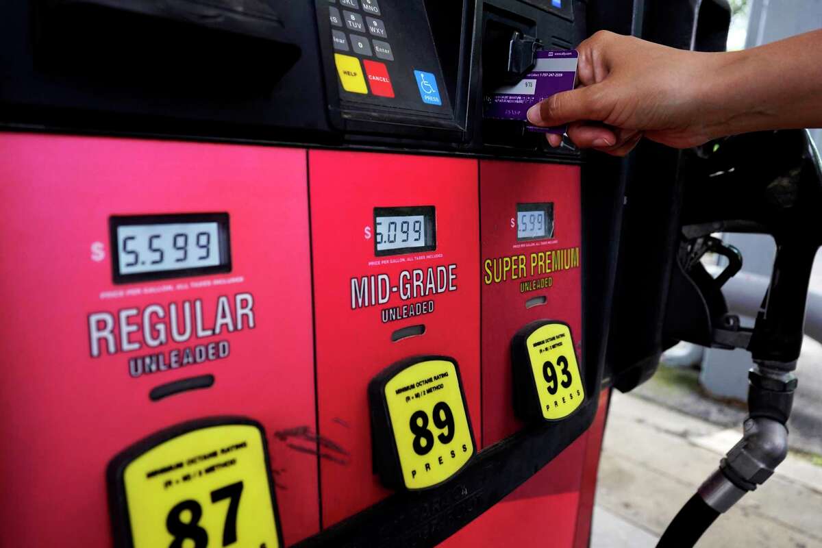A customer holds a credit card at the pay-at-the-pump gasoline pump in Rolling Meadow, Ill., Thursday, June 30, 2022. The U.S. economy shrank from April through June for a second straight quarter, contracting at a 0.9% annual pace and raising fears that the nation may be approaching a recession. The decline that the Commerce Department reported Thursday, July 28, in the gross domestic product — the broadest gauge of the economy — followed a 1.6% annual drop from January through March.